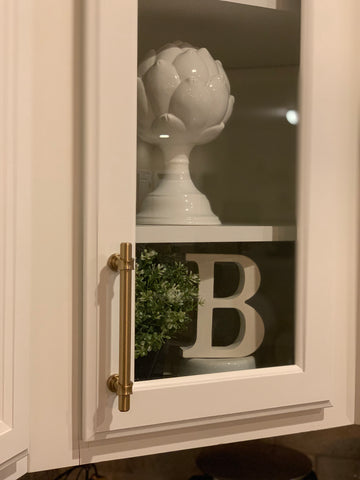 brushed brass cabinet pull on white showcase cabinet